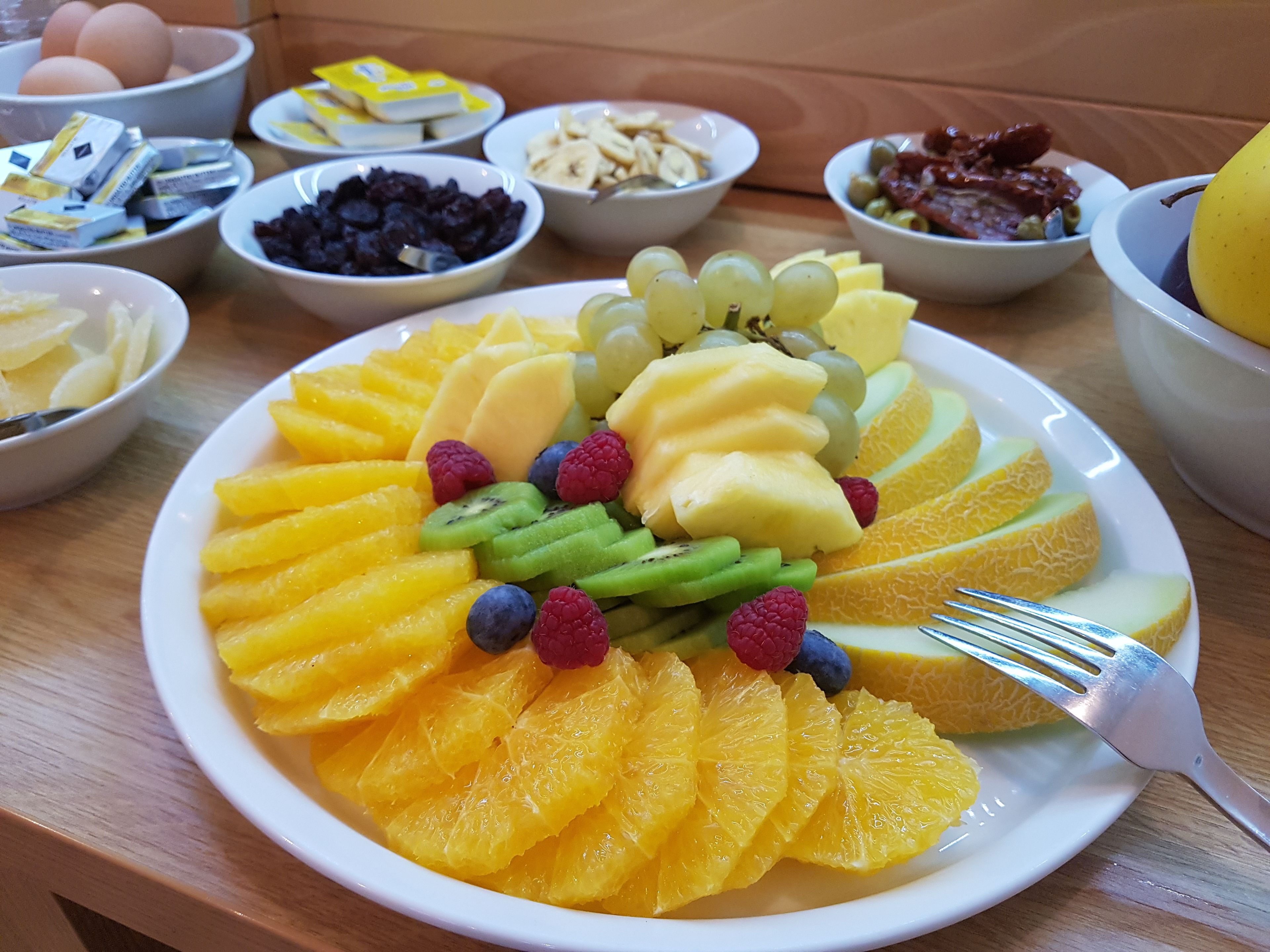 A breakfast buffet with various fruits and cereals.