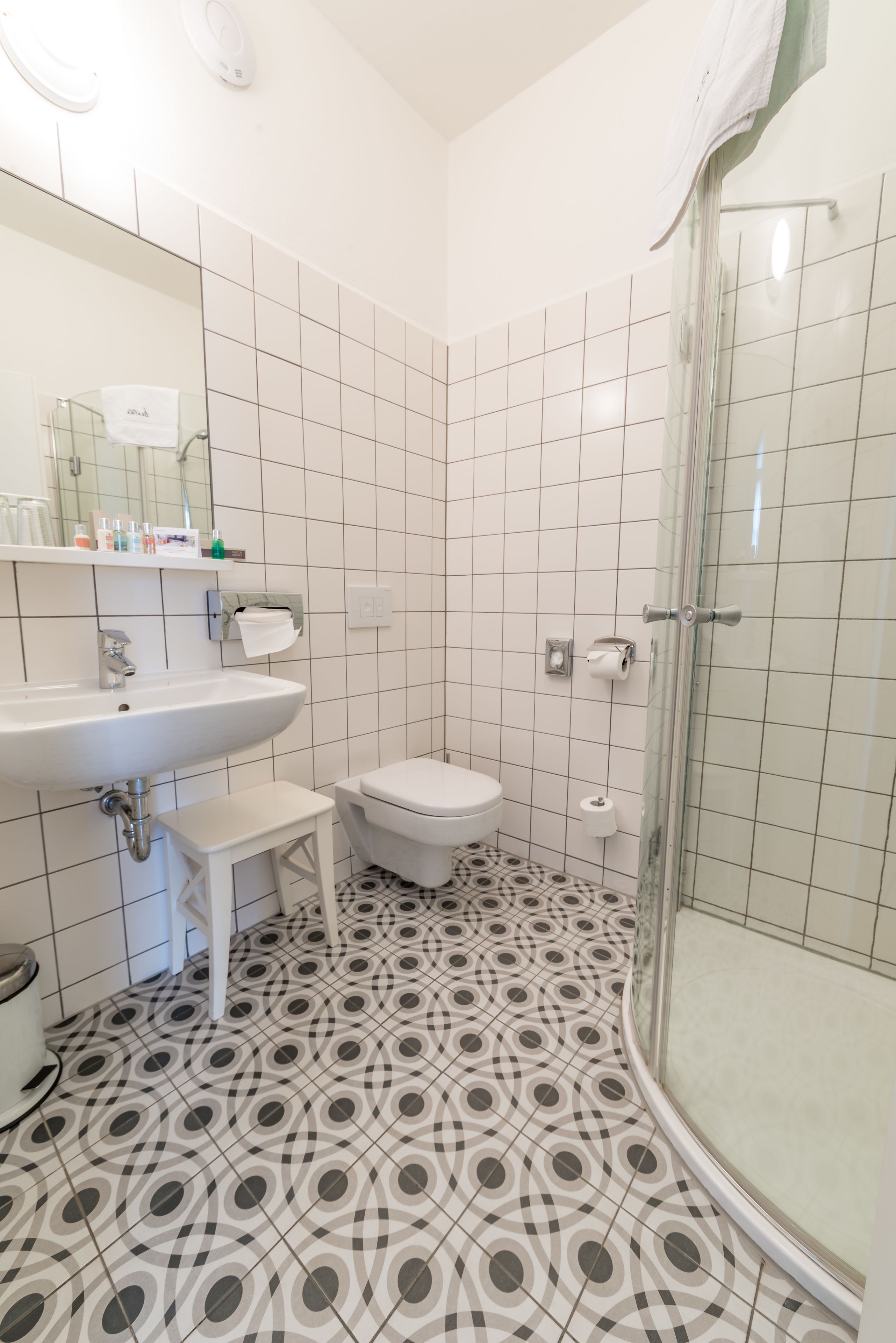 Un baño con lavamanos blanco, inodoro y cabina de ducha de vidrio.