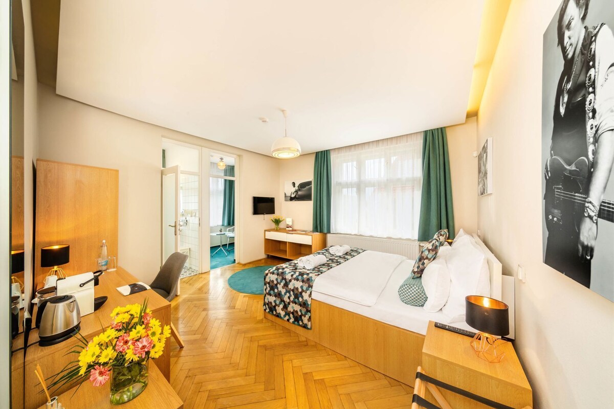 Una habitación de hotel con cama, escritorio, silla y televisión.