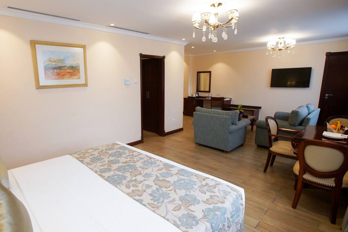 Une chambre d’hôtel comprenant un lit, un canapé, une table à manger et un téléviseur.