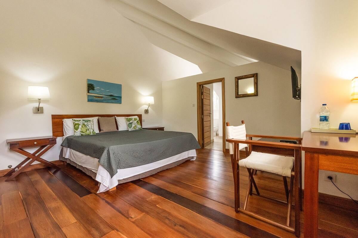 Ein Schlafzimmer mit einem Bett, Nachttischen, einem Schreibtisch und einem Stuhl.
