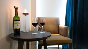 A table with a bottle of wine and two glasses of red wine, a lit candle, and a chair. - Hôtel de la Tabletterie (Meru)
