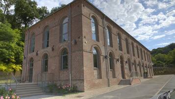 A brick building with arched windows and a staircase leading to the entrance.