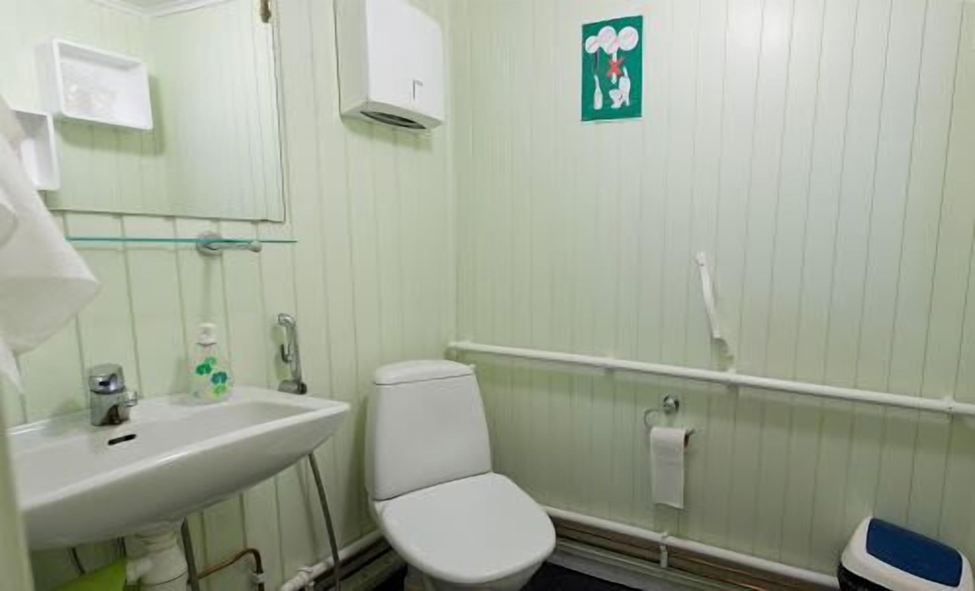 Ein kleines Badezimmer mit Waschbecken, Toilette und Spiegel.