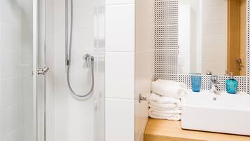Ein modernes Badezimmer mit einer gläsernen Duschkabine, einem Holzbadezimmer-Möbel mit Waschbecken und einer gefliesten Wand mit dekorativem Muster.