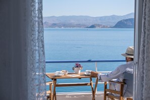 Un homme est assis à une table, devant laquelle s’étend un lac paisible et, au loin, des montagnes.