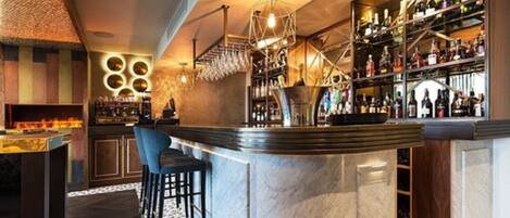 A bar area with a marble counter, stools, and a wine rack filled with bottles.