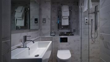 A modern bathroom with a large sink, a toilet, and a glass-enclosed shower area.
