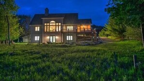 A large, two-story house with a well-lit front entrance and a covered porch.