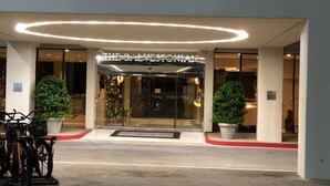Indgangen til The Galveston Inn med et moderne design, med en glasfacade og en rund lampe over indgangen.