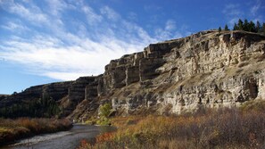 A river flowing through a canyon with layered rock formations and autumn foliage. - Come Stay in Belt Montana - Authentic Western, Historic, Memorable (Belt)
