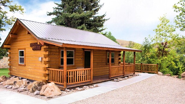 A wooden cabin with a metal roof, a porch, and a gravel driveway. - Come Stay in Belt Montana - Charming, Historic, Memorable (Belt)