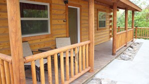 A wooden cabin with a porch, outdoor seating, and a door leading inside. - Come Stay in Belt Montana - Charming, Historic, Memorable (Belt)
