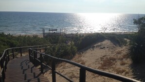 A wooden boardwalk leading to a beach with a sandy dune and ocean view. - Private flat in Rome Ostia Antica (Ostia Antica, Roma)