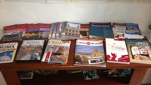 A collection of travel guides and books on a wooden table. - Private flat in Rome Ostia Antica (Ostia Antica, Roma)