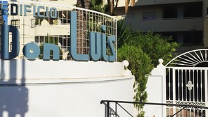 Ein Gebäude mit einem Schild, auf dem „EDIFICIO Don Luis“ steht, und einem befahrbaren Eingangstor.