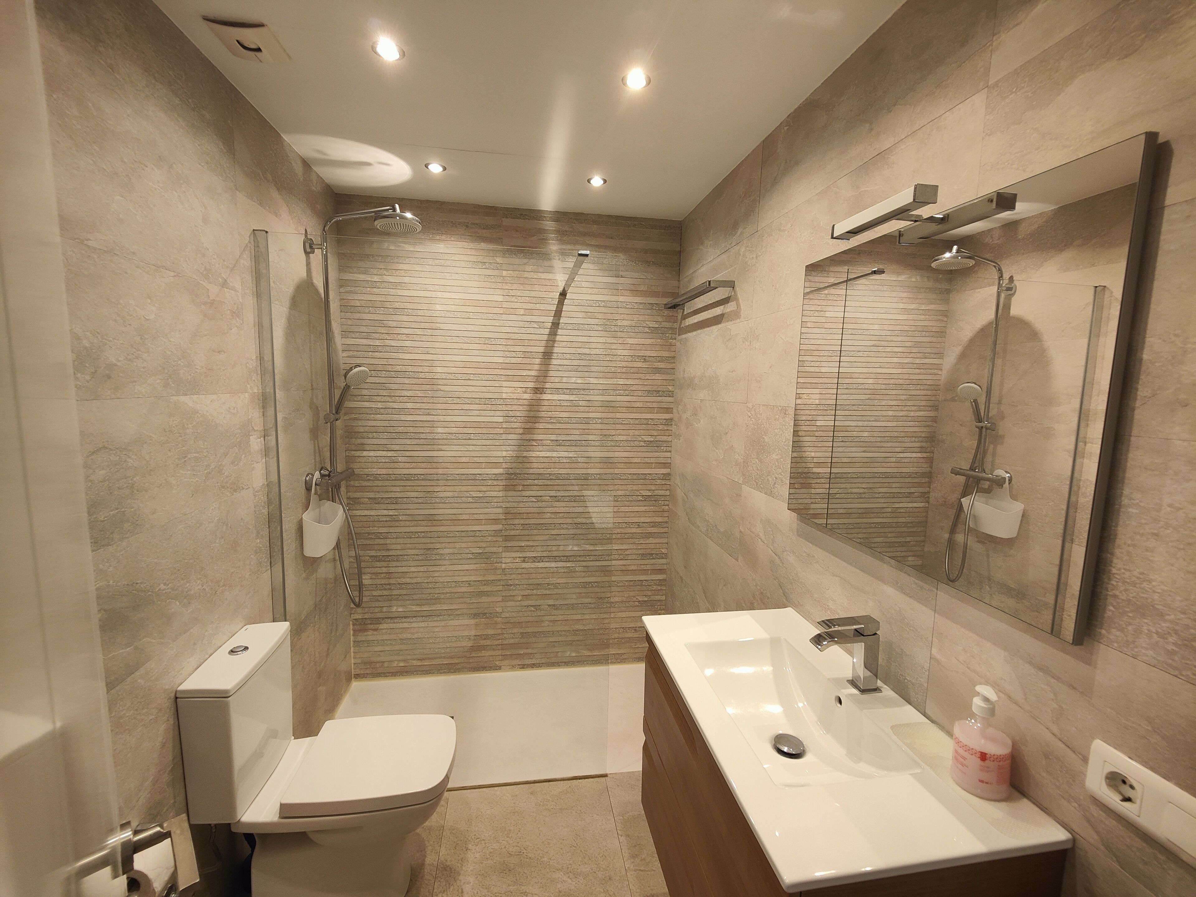 Ein modernes Badezimmer mit Dusche, Toilette und Waschbecken.