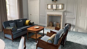 A traditional living room with a sofa, chairs, a coffee table, and a fireplace. - Shieldhill Castle Hotel (Biggar)