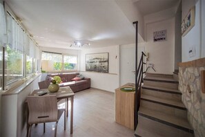 A spacious living area with a sofa, a coffee table, and a staircase leading to another level.