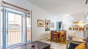 A compact living space with a dining area, kitchen, and a balcony with a railing. - IN OFFER - LUXURY HOUSE WITH TERRACE IN LA JUDERIA, PAX 10 (SEVILLA)