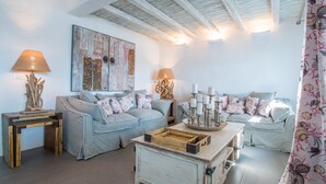 Ein Wohnzimmer mit einer Sofagarnitur, einem Holztisch und einem Wandbild.