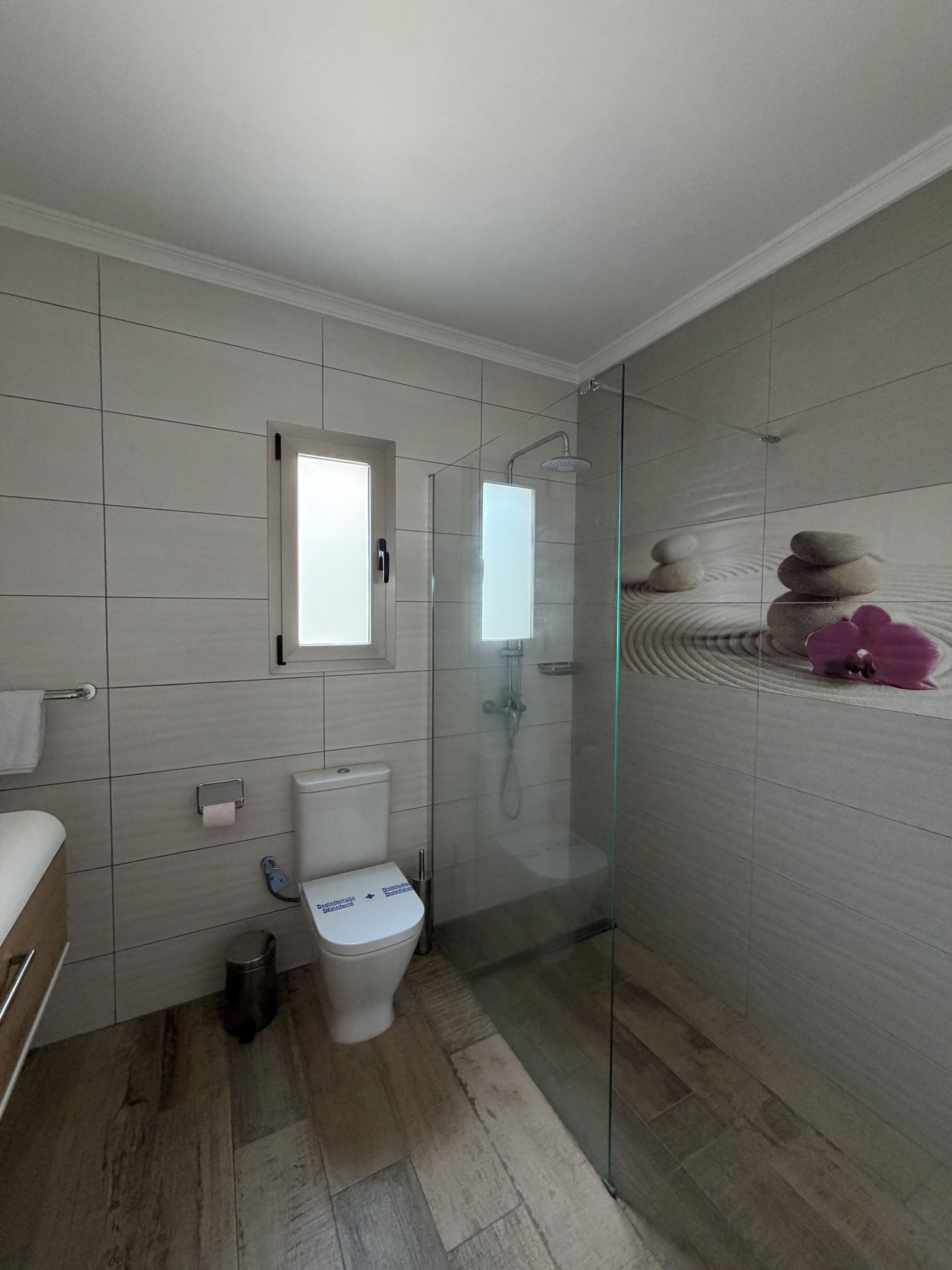 Uma casa de banho moderna com sanita, bidé e cabine de duche em vidro.