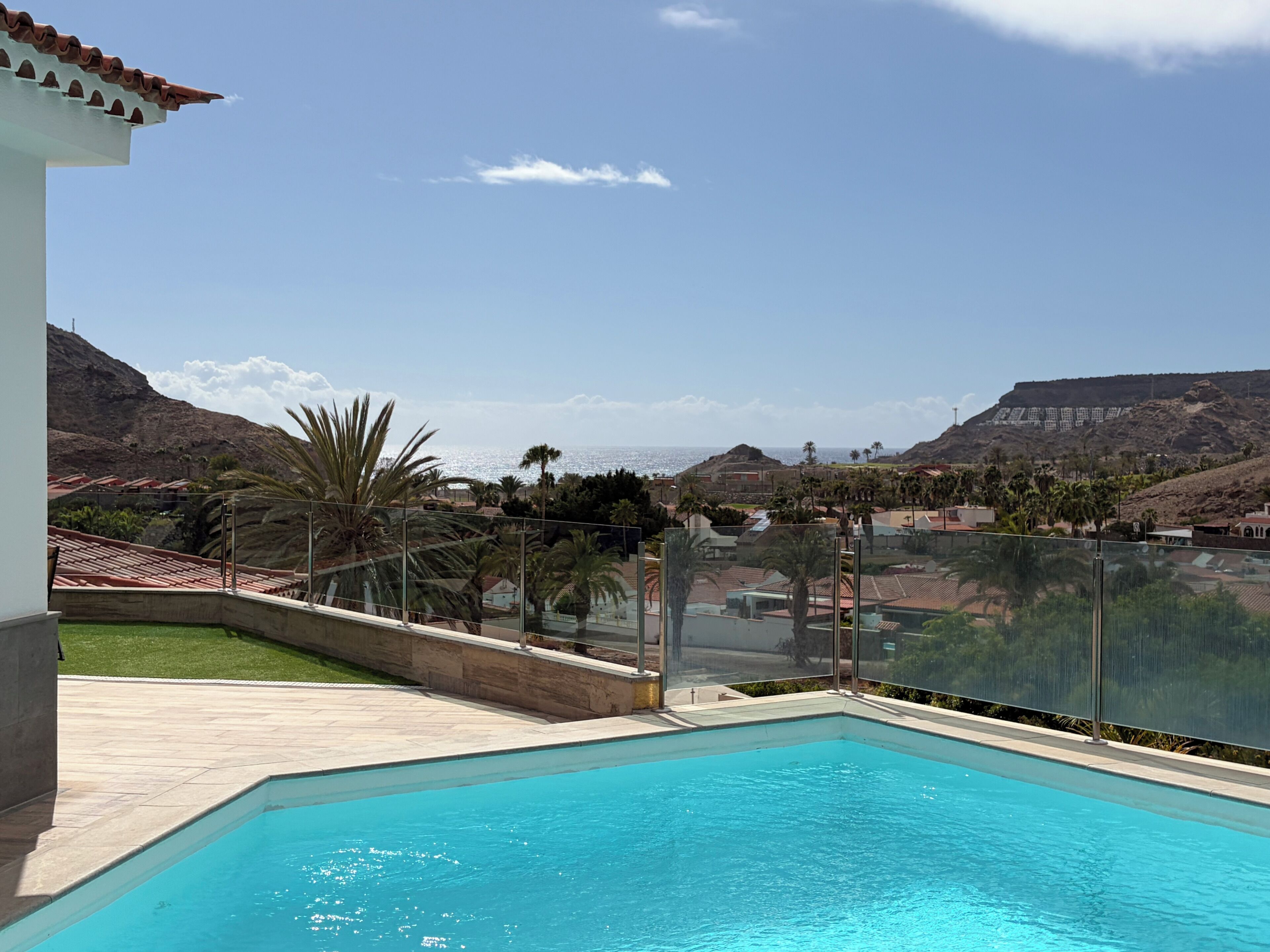 A swimming pool with a view of a mountainous landscape and a clear sky.