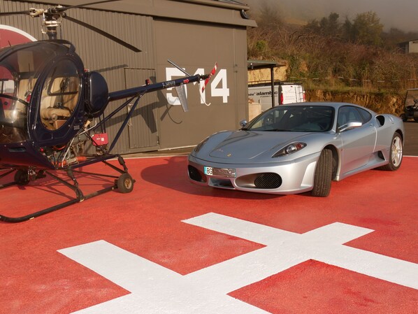 Un helicóptero estacionado junto a un edificio con un diseño rojo y blanco en el suelo.
