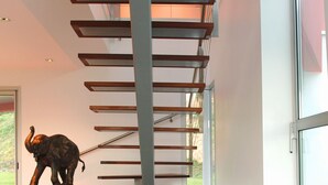 A modern staircase with a metal railing and a decorative elephant sculpture on the landing.