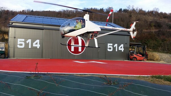 A helicopter parked in front of a building with the number 514.