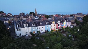 A coastal town with colorful houses, a prominent church tower, and a view of the sea. - Fossil Bank, a luxury detached retreat in the heart of Alnmouth, with parking (Alnmouth)