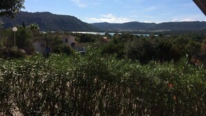 En vy från under en bro, med utsikt över en dal med berg, en sjö och några byggnader.