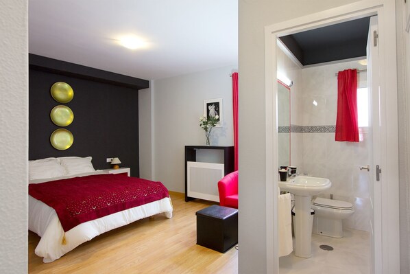 A bedroom with a bed, bedside table, and a red throw blanket. - 1-bedroom, private terrace, Santa Cruz quarter (Sevilla)