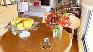 A dining table with a fruit bowl and a vase of flowers.