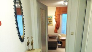 Un pasillo con una consola de madera, un espejo y una obra de arte enmarcada en la pared.