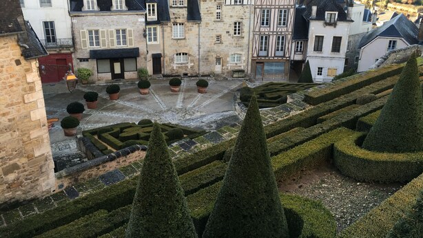 A historic courtyard with a central fountain, surrounded by stone buildings with traditional architecture. - The Périgord houses on the abbey side  (Terrasson-Lavilledieu)