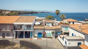 A coastal town with terracotta-roofed buildings, a clear blue sea, and mountains in the background. - Blue 54 - Seaside house with terraces overlooking the sea, Etna and Taormina (Pozzillo)