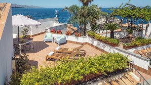 A rooftop terrace with outdoor seating, potted plants, and a view of the sea. - Blue 54 - Seaside house with terraces overlooking the sea, Etna and Taormina (Pozzillo)