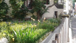 Um edifício com jardim na frente, um caminho de pedras e uma cerca.