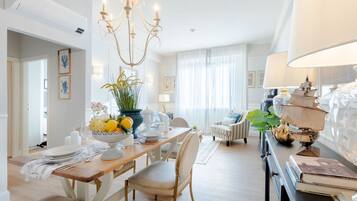 Un'area pranzo con un lampadario, un tavolo apparecchiato per quattro e una lampada a forma di nave su un credenza.