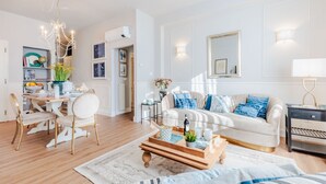 Ein modernes Wohnzimmer mit Sofa, Couchtisch und Essbereich.