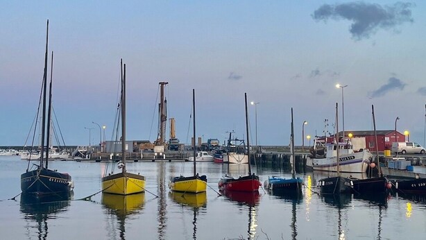 Ein Yachthafen mit mehreren Booten, die bei Ebbe liegen.