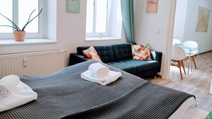 Een moderne hotelkamer met een bed, een bank en een eethoek.