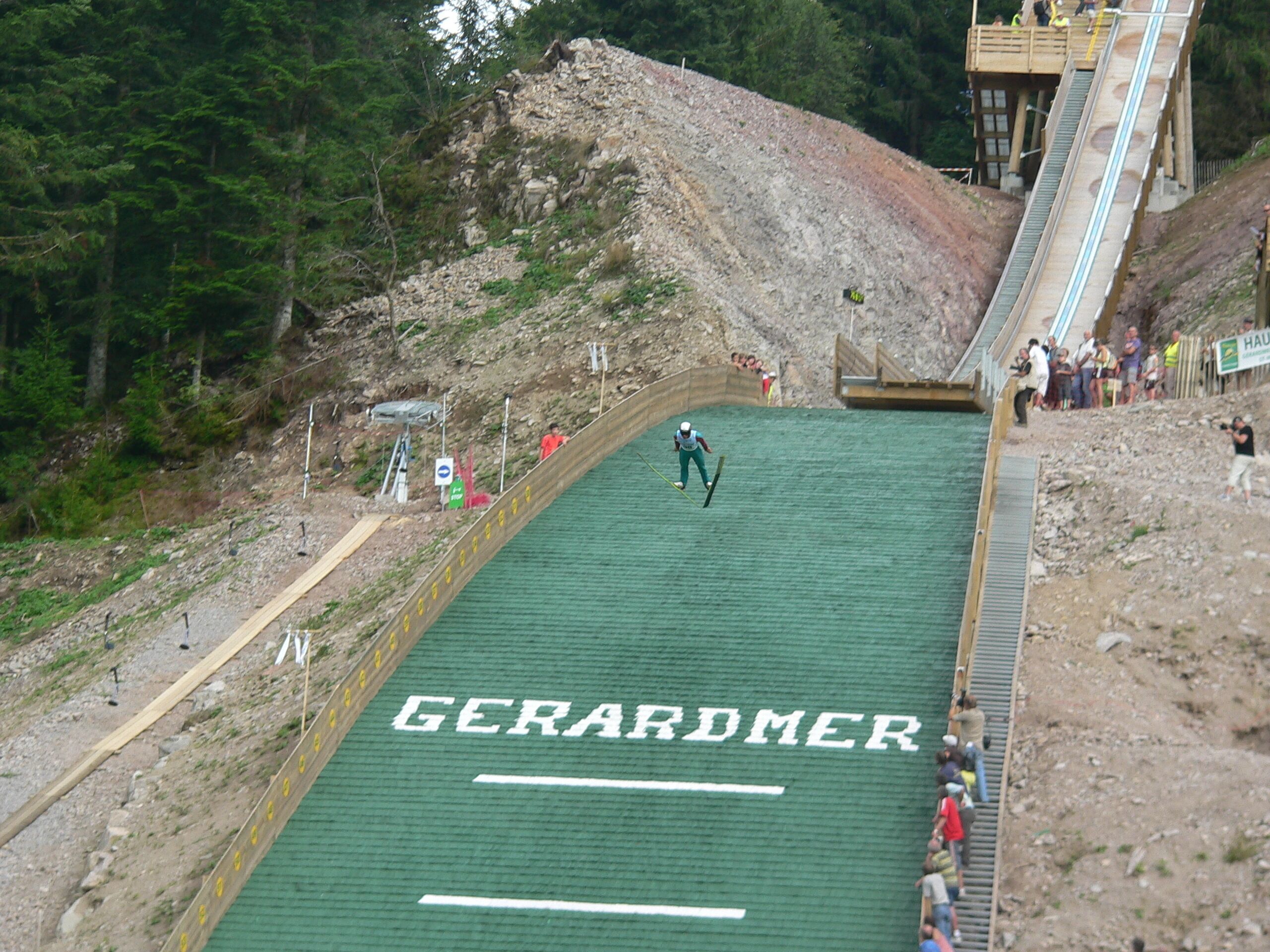 Eine Skipiste mit dem Schriftzug 'GERARDMER', umgeben von einem bewaldeten Gebiet.