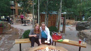 Two people sitting on a bench with a fire pit in front of them. - The Springs, Extra Large Condo.  Cool winter deals! (Keystone)