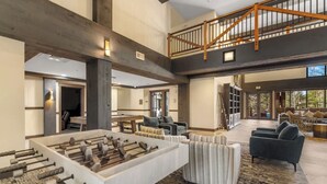 A spacious living area with a foosball table, comfortable seating, and a high ceiling with exposed beams. - The Springs, Extra Large Condo.  Cool winter deals! (Keystone)
