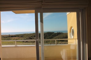 A balcony with a view of the sea and hills.
