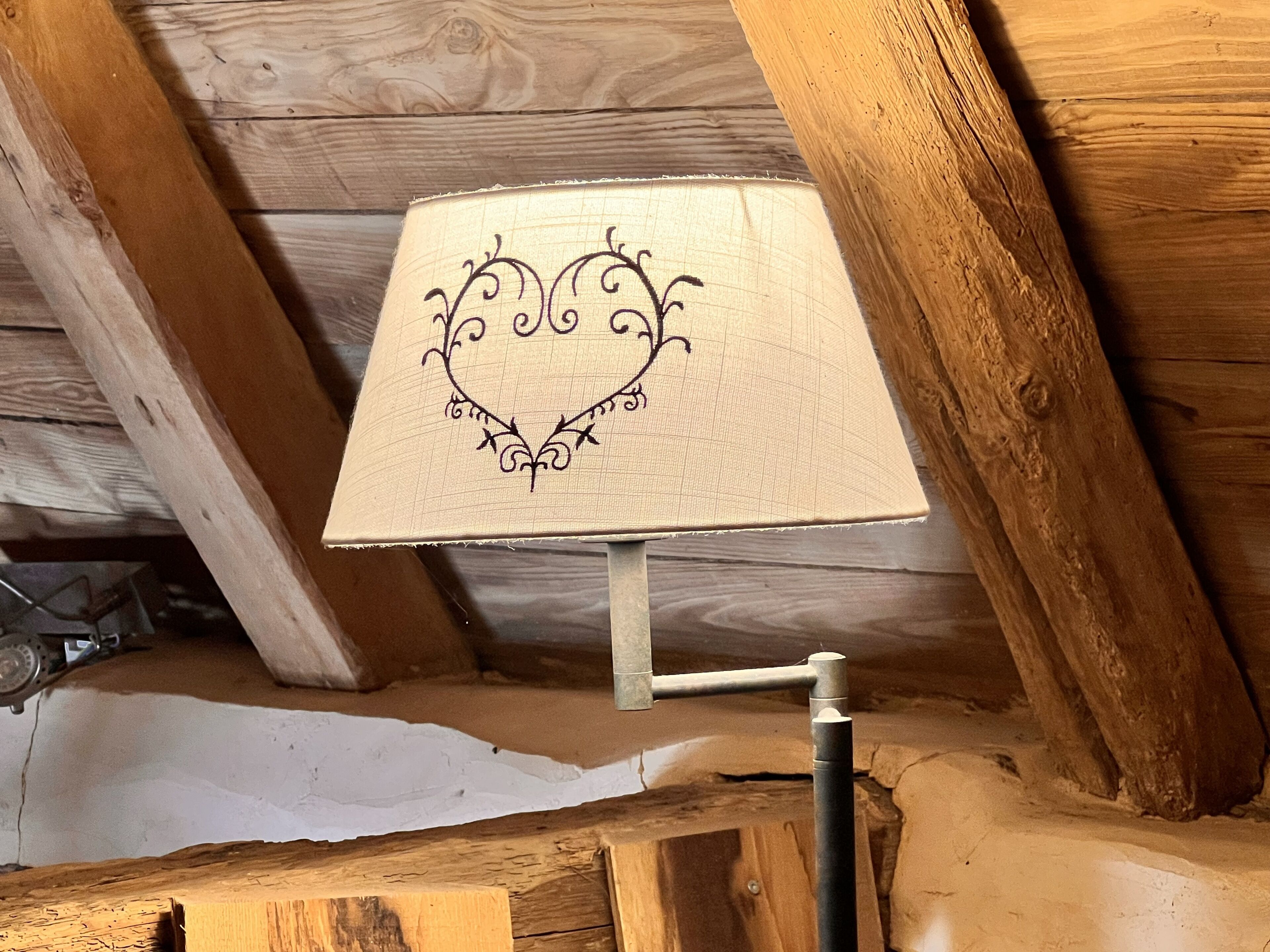 A lamp with a decorative design on a wooden ceiling.