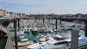 Un port de plaisance où de nombreux bateaux de différentes sortes sont amarrés à des quais en bois.