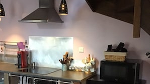 Une cuisine dotée d’un îlot central, d’un four à micro-ondes et de divers ustensiles.